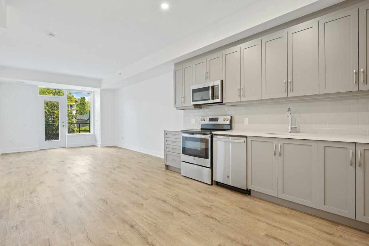 Bright, empty apartment with a freshly cleaned kitchen and floors ready for a new tenant