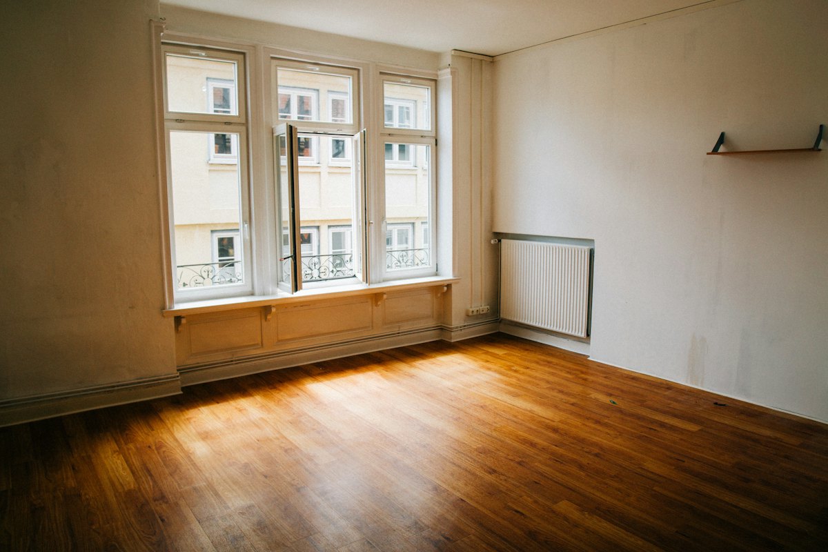 Empty, freshly cleaned room with shining hardwood floors ready for move-in